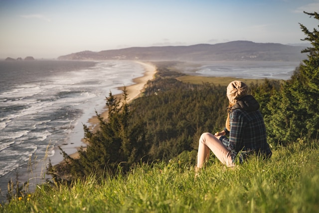 Girl on sitting to watch coastal view. Photo by Suhyeon Choi on Unsplash