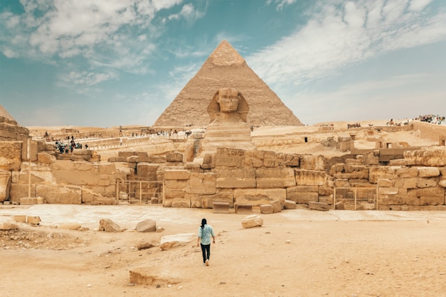 Woman walking to pyramid Photo by Spencer Davis on Unsplash
